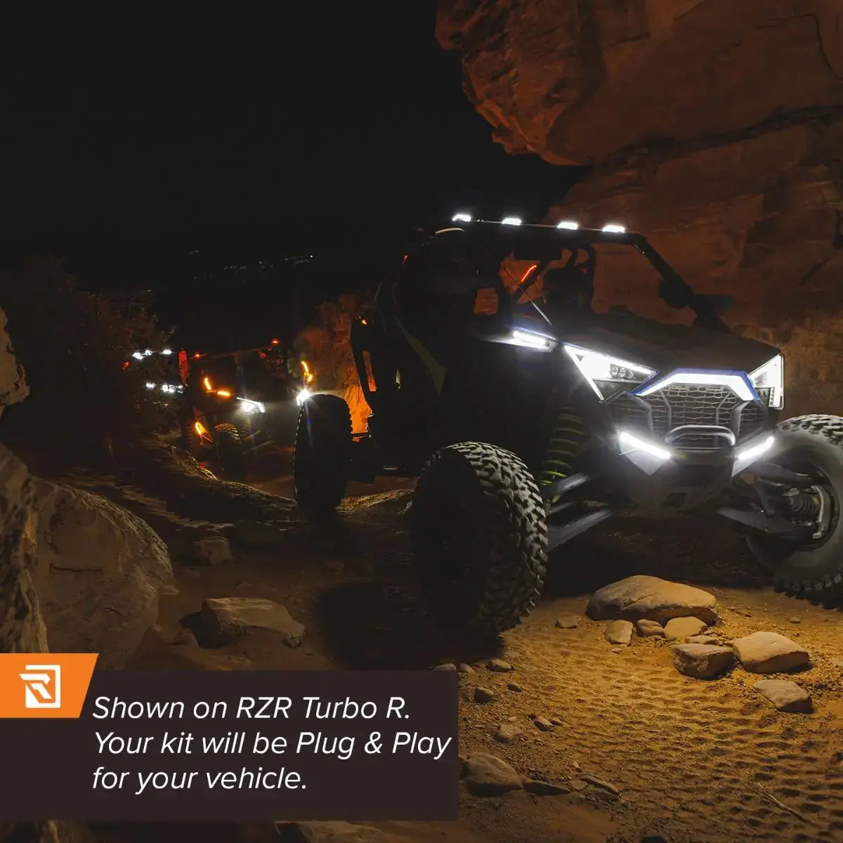 Off-road vehicle with lights on a rocky terrain at night