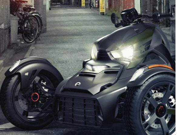 Can-Am Ryker three-wheeler front view with LED auxiliary lights illuminated, black finish