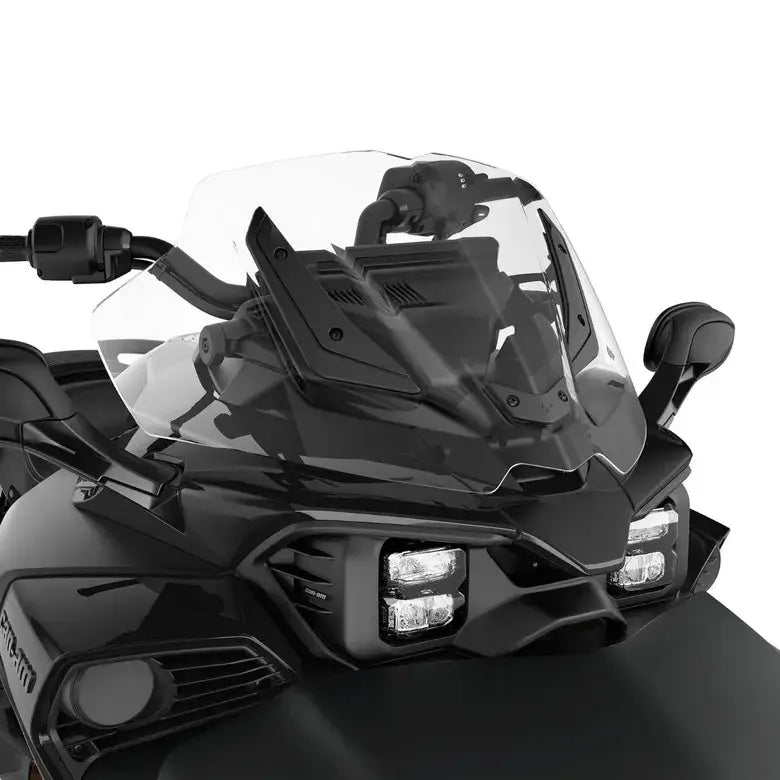 Close-up of a motorcycle's front section with windshield and lights on a white background