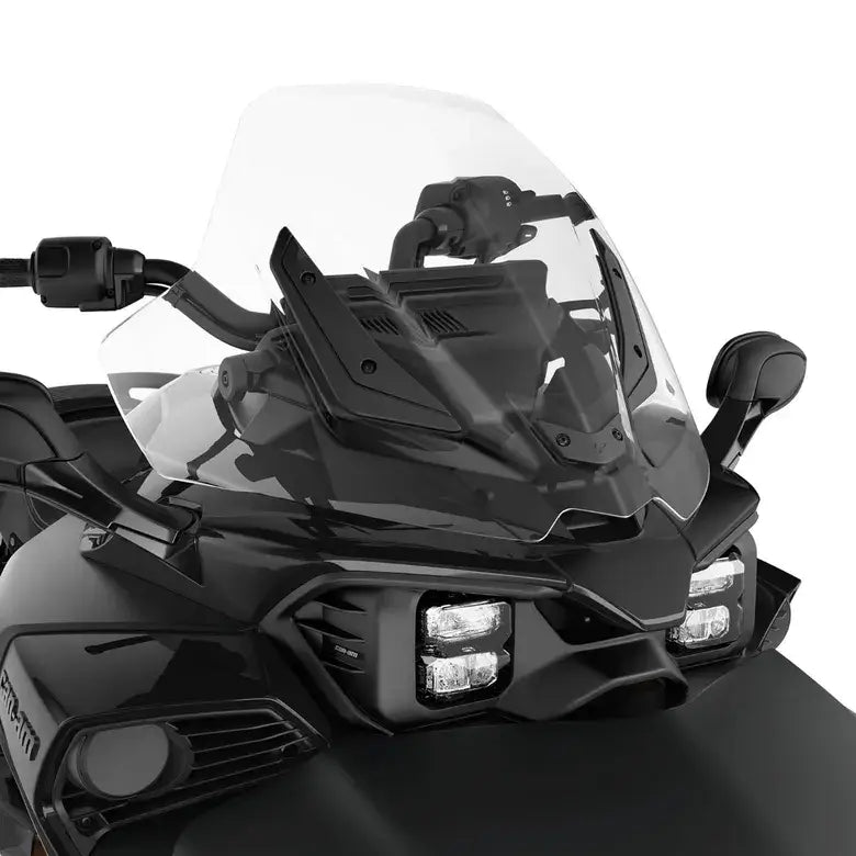 Close-up of a motorcycle's front windshield and headlight on a white background