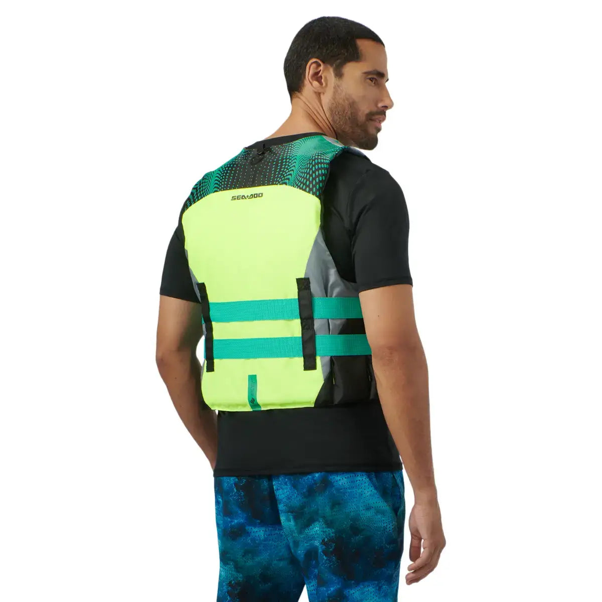 Man wearing a Sea-Doo Motion PFD life jacket, showcasing its bright design and adjustable straps for safety.