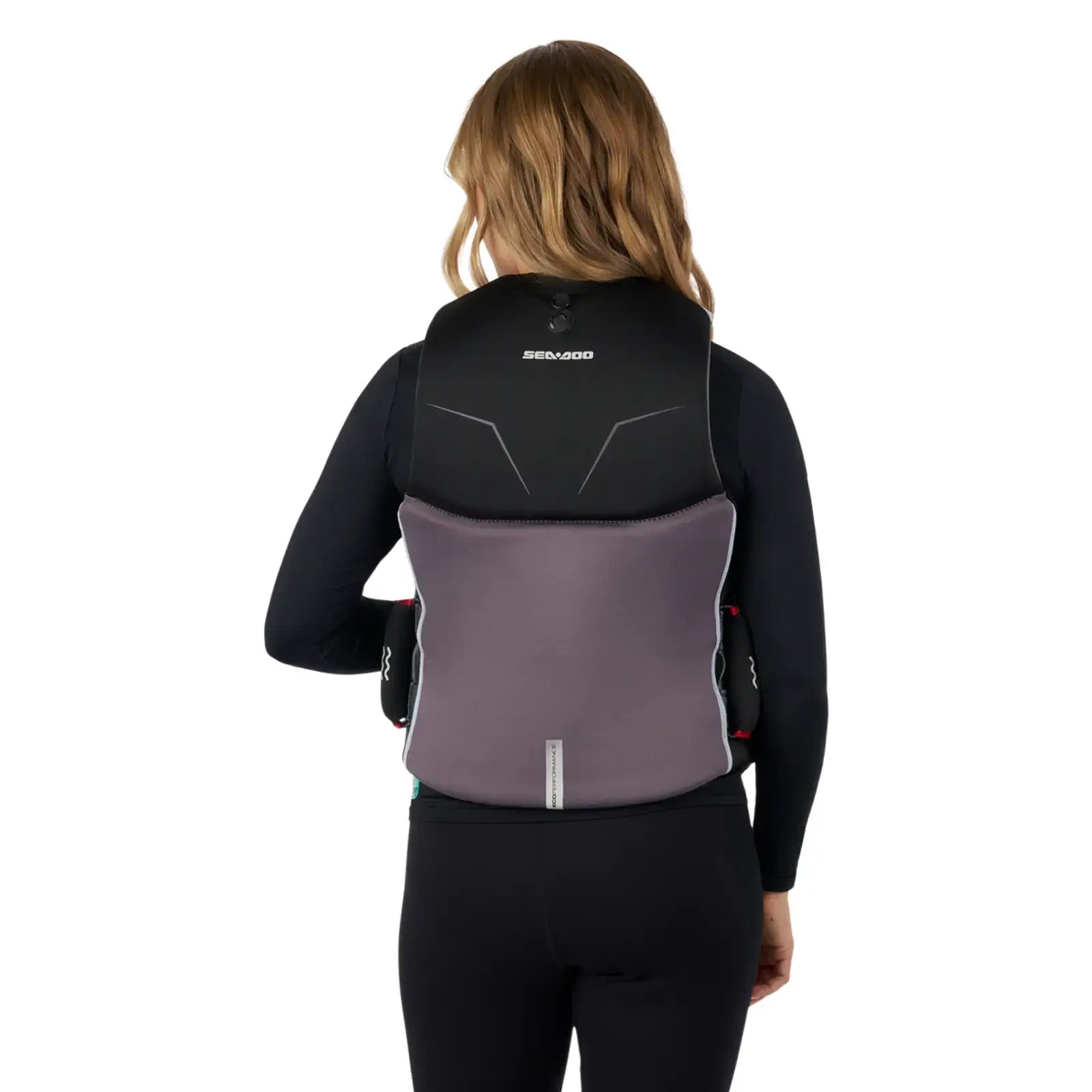 A woman wearing a Sea-Doo Wave Grip PFD life jacket, showcasing its eco-friendly design and side handles.