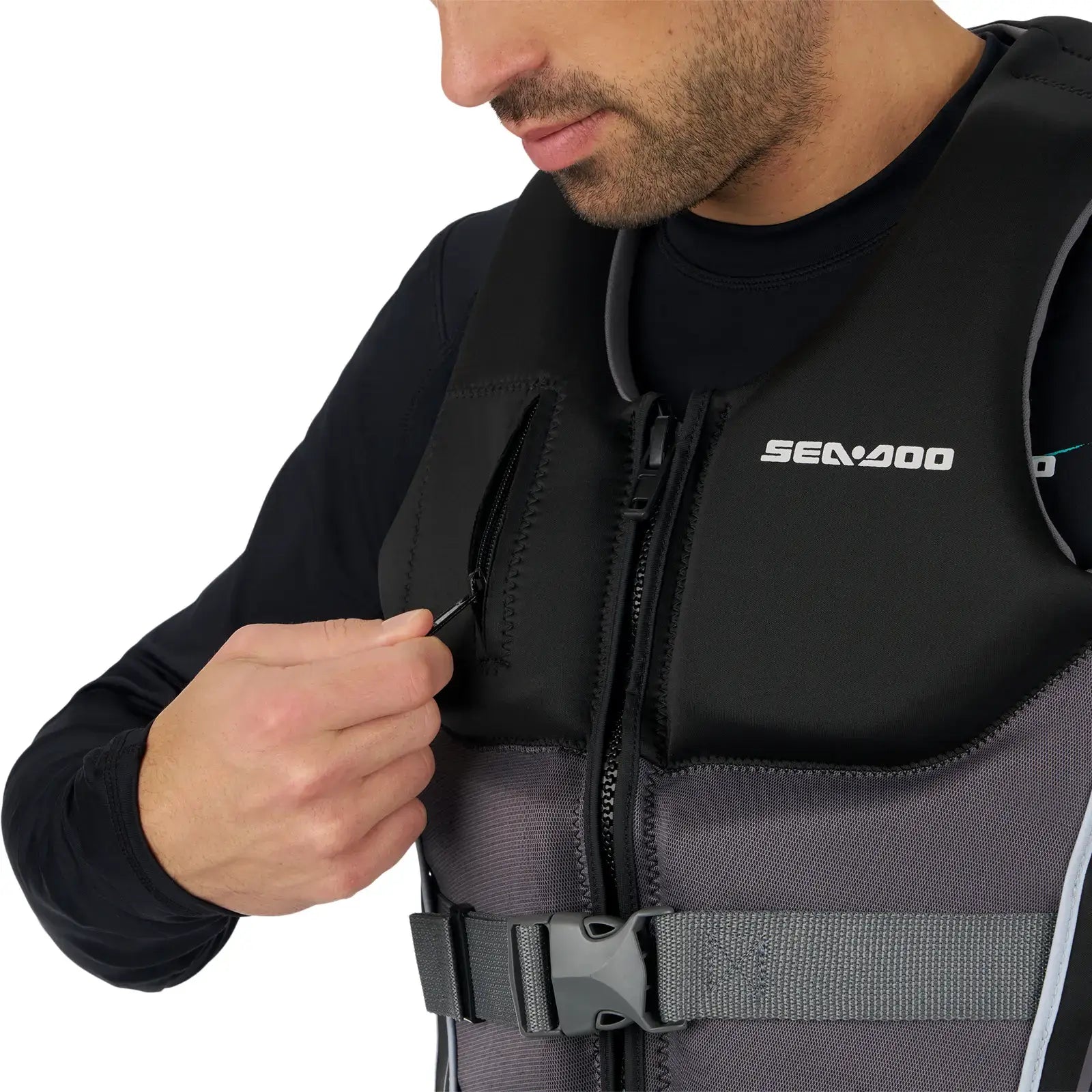 Close-up of a man wearing a Sea-Doo Wave Grip PFD, adjusting the zipper on a black and gray life jacket.