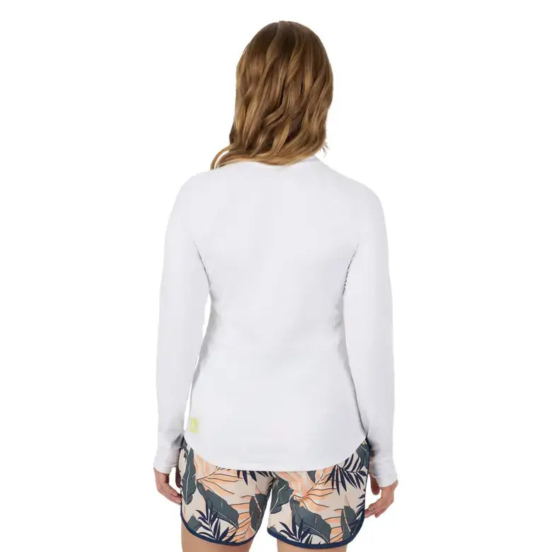 Back view of a woman wearing the Sea-Doo Women's UV Protection Long Sleeve Shirt, paired with patterned shorts.