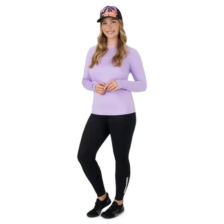 Model wearing a Women's UV Protection Long Sleeve Shirt from Sea-Doo with black leggings and a cap.