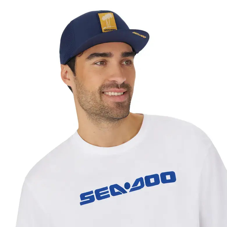 Unisex Sea-Doo Laser Cut Mesh Cap with palm tree design and Sea-Doo logo, worn by a man in a white shirt.