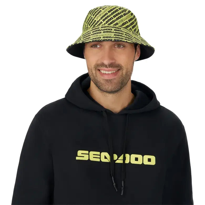 Man wearing a Sea-Doo reversible bucket hat, showcasing stylish design with logo, paired with a black hoodie.