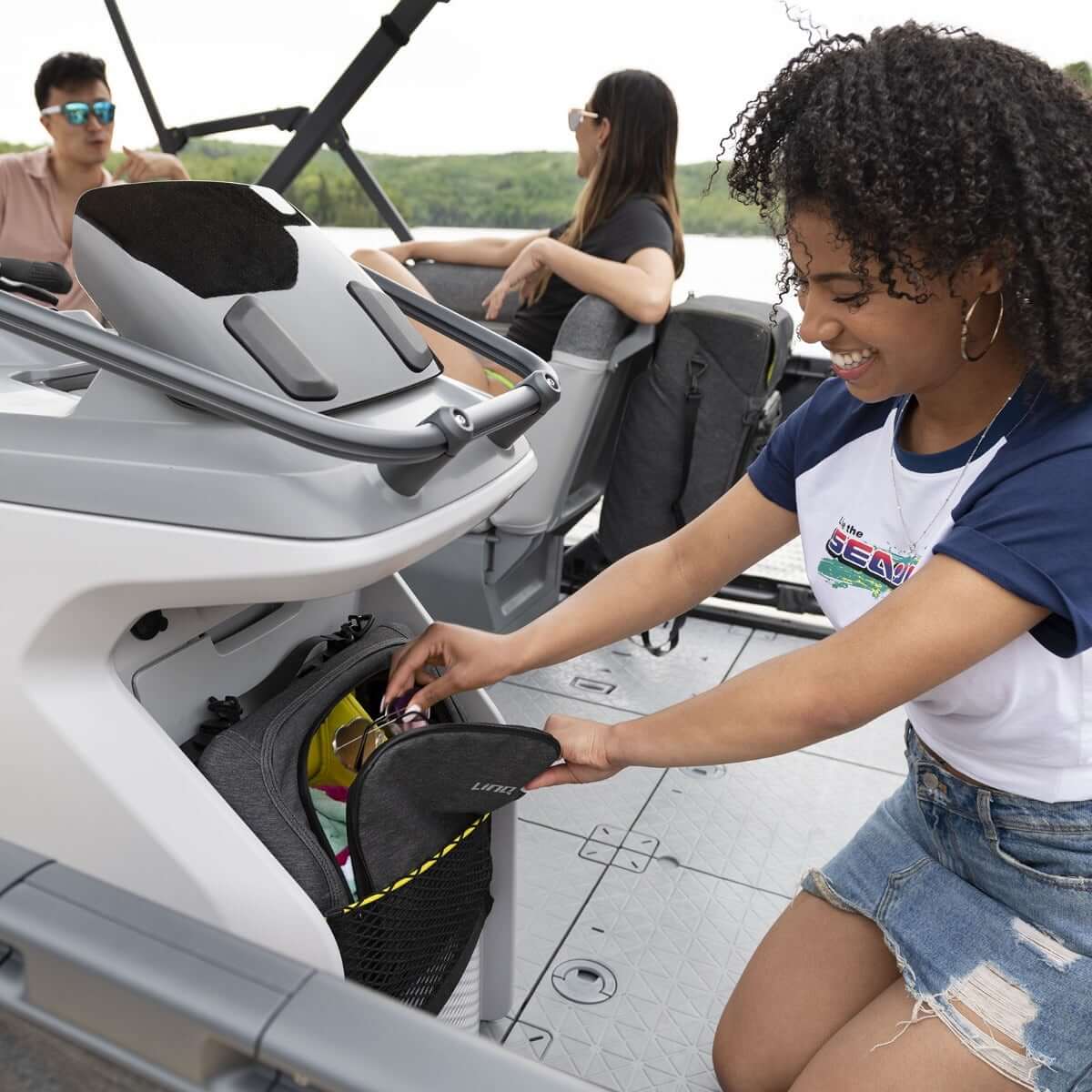 A woman putting a bag in the back of a boat