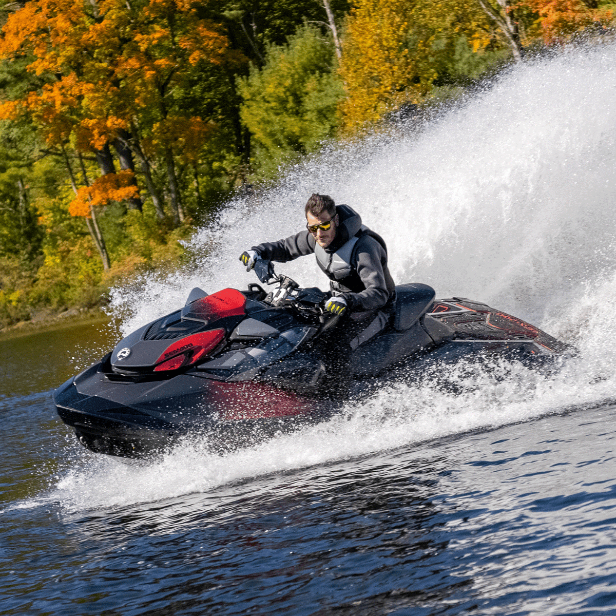 Rider carving turn on black and red Sea-Doo RXT-X personal watercraft with Ergolock seat, spraying water