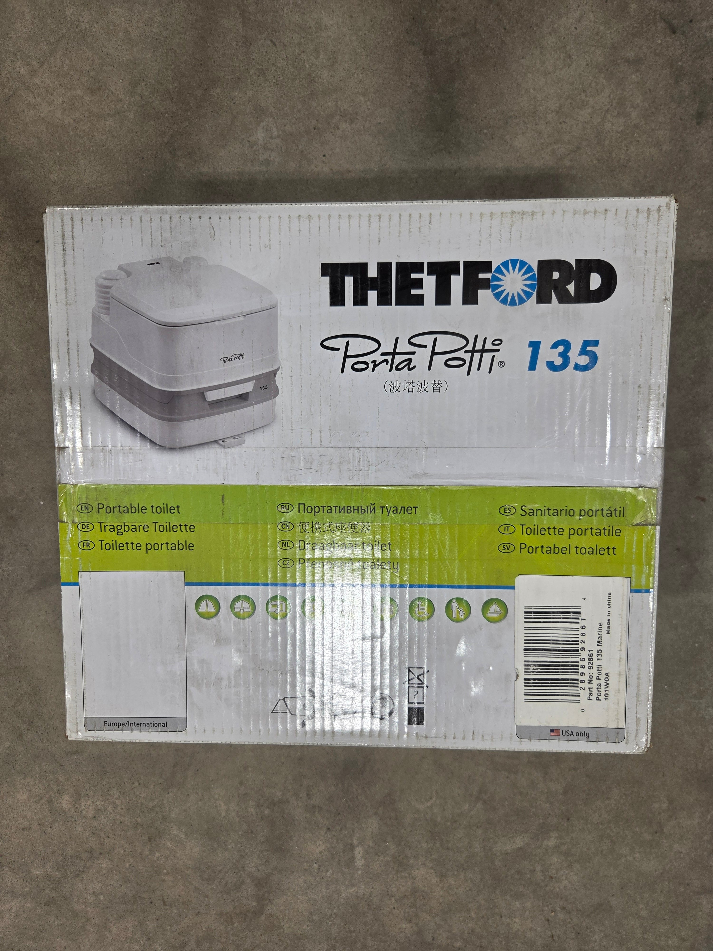 TheTFORD 135 Wh electric kettle packaging box, showing the front and side panels with product details and a barcode, placed on a gray carpeted floor.