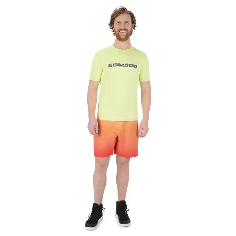 Man wearing a light green t-shirt and orange shorts with a sea-doo brand logo on a white background