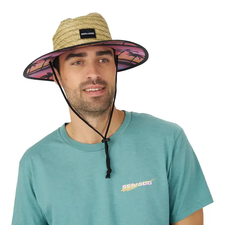 Man wearing a Sea-Doo straw hat with logo and printed brim, showcasing a sporty and stylish sun protection accessory.