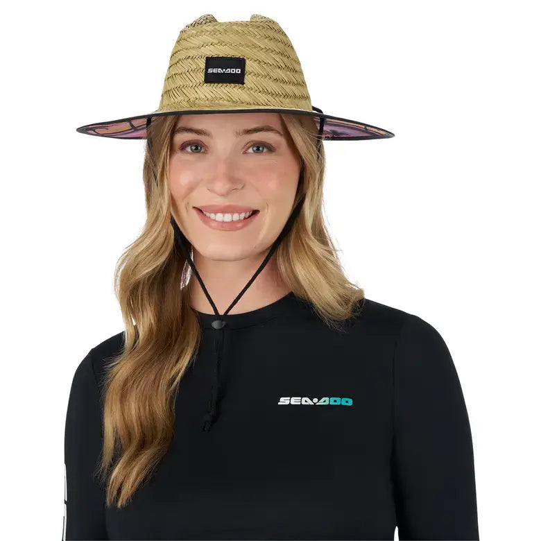 Unisex Sea-Doo straw hat with logo, printed brim, and adjustable chin strap worn by a model.