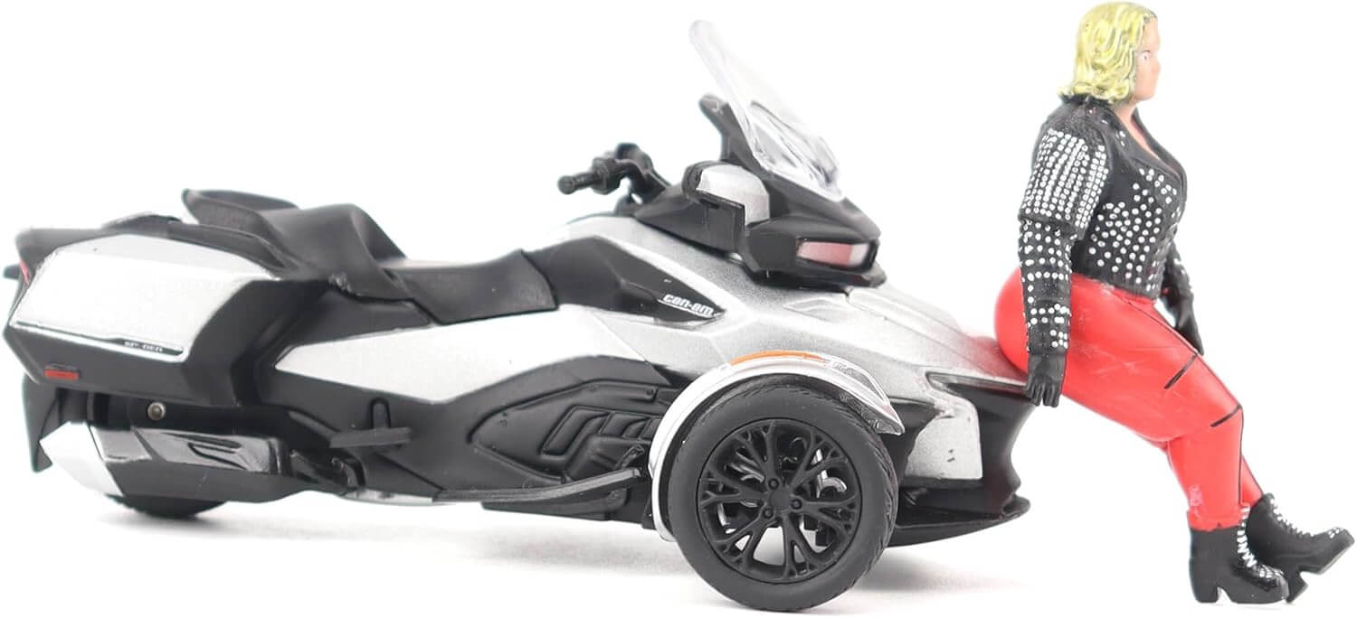 Model of a three-wheeled model vehicle with a person figure leaning against it on a white background