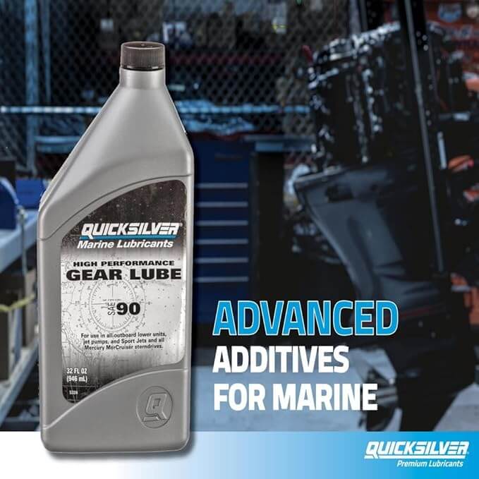 Quicksilver marine lubricant bottle with text about advanced additives for marine use, set against a blurred workshop background.