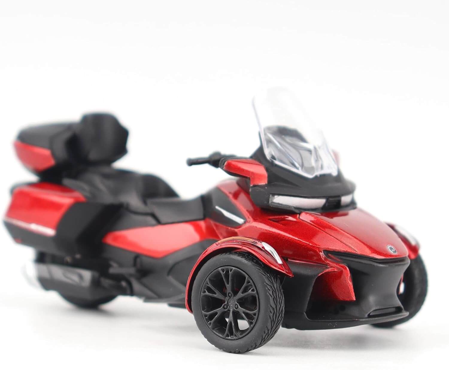 Red and black three-wheeled toy vehicle model on a white background