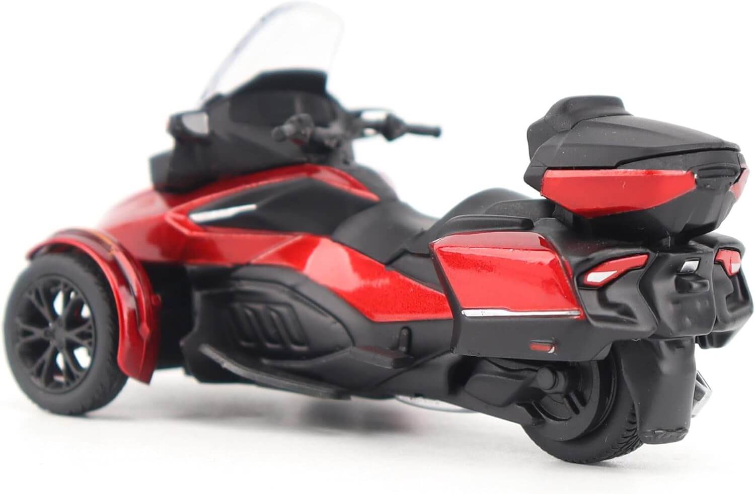 Red and black three-wheeled toy motorcycle on a white background