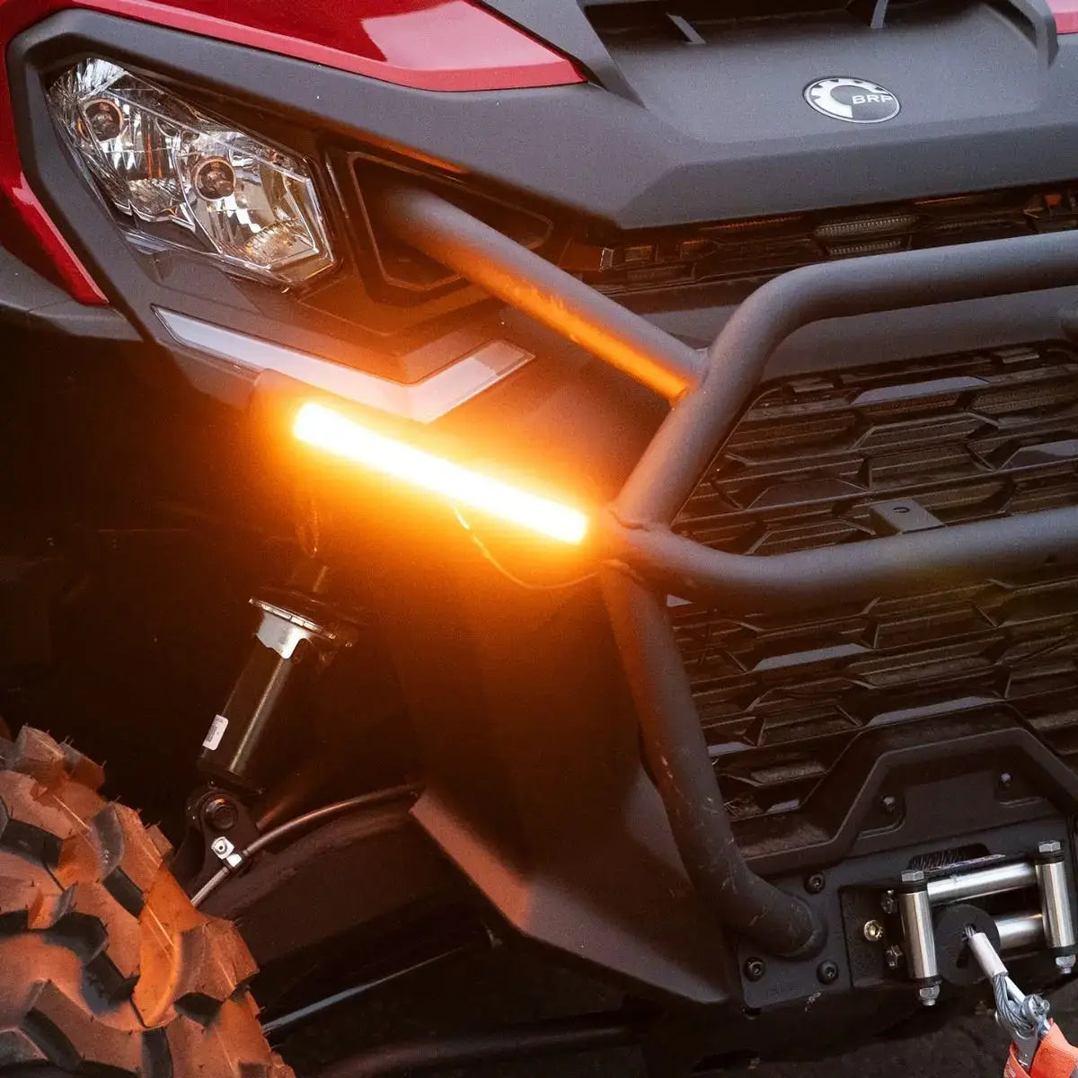 Close-up of an ATV with a visible BRP brand logo, focusing on the front grille and headlight.