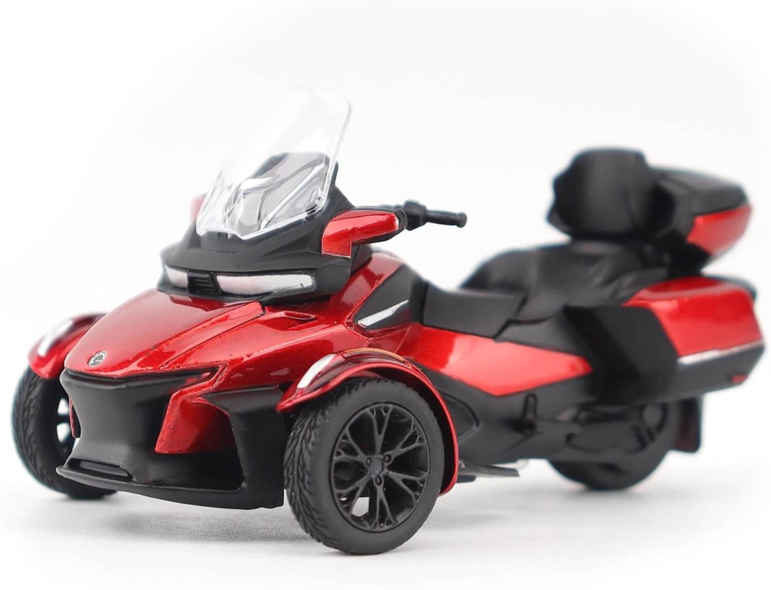 Red and black three-wheeled motorcycle toy model on a white background