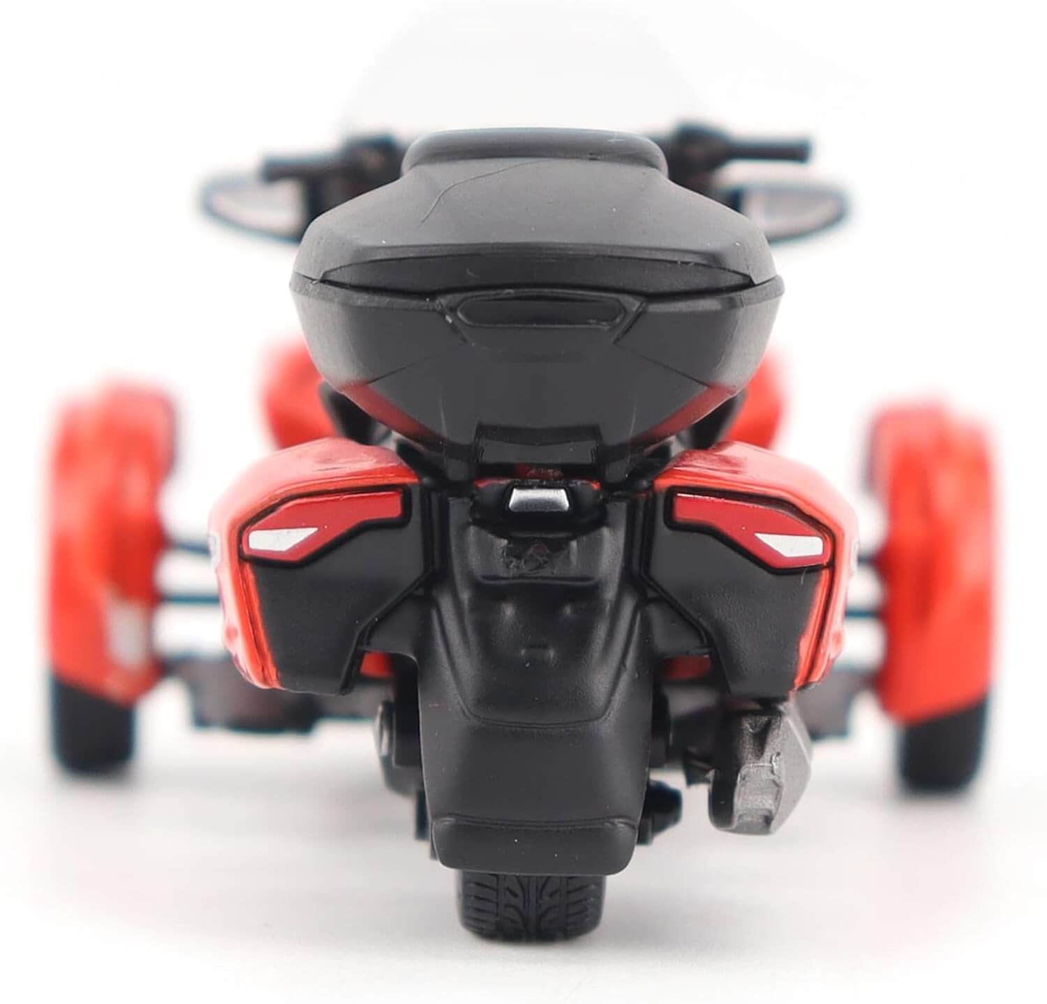 Close-up of a red and black toy three wheel motorcycle on a white background