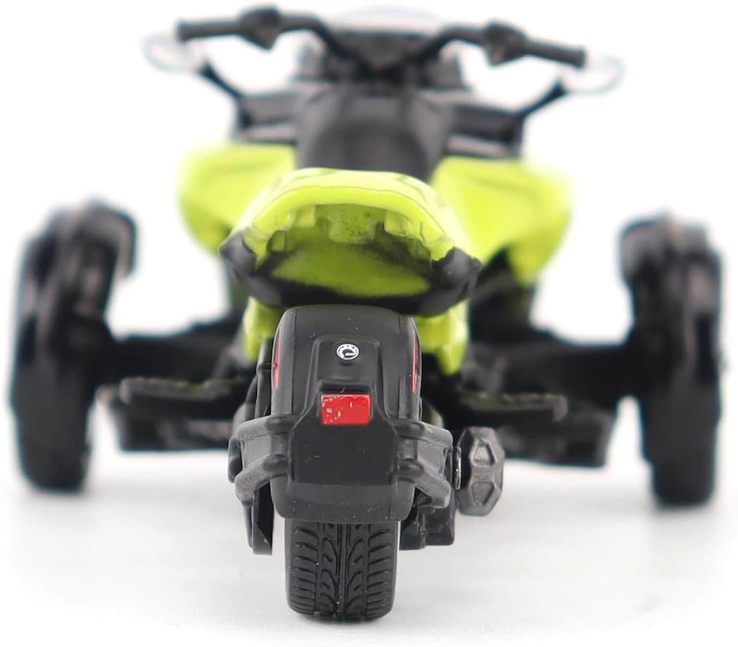 Close-up of a toy three wheel motorcycle with a focus on the rear wheel.