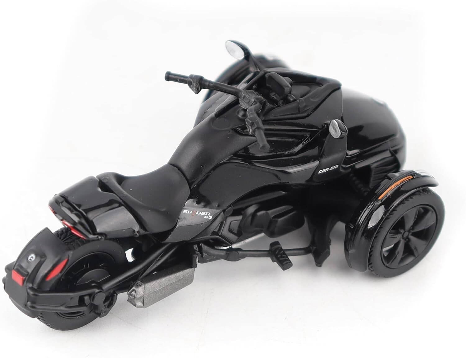 Black toy motorcycle with three wheels on a white background