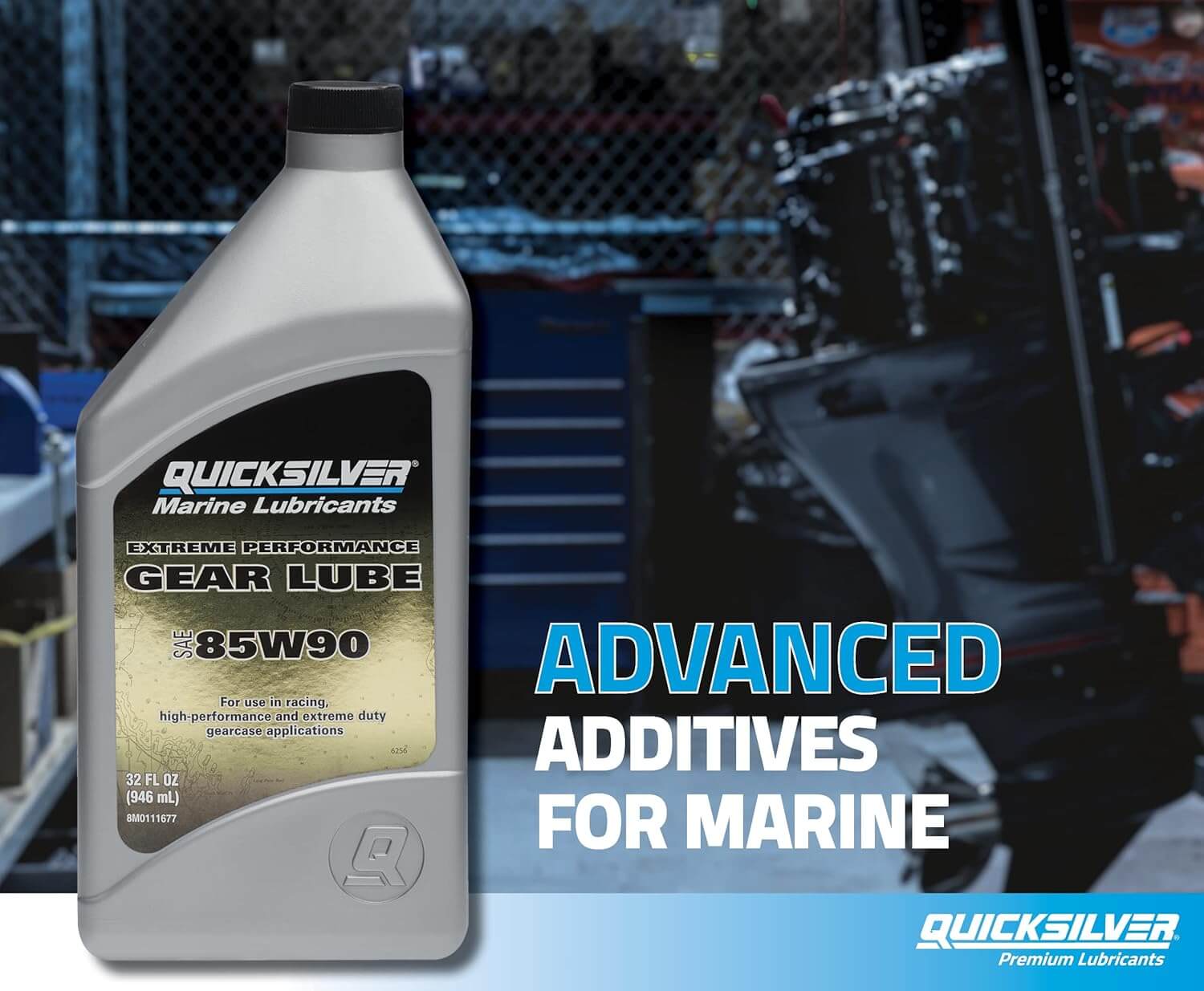 Quicksilver marine gear lube bottle with text about advanced additives for marine use, set against a blurred workshop background.