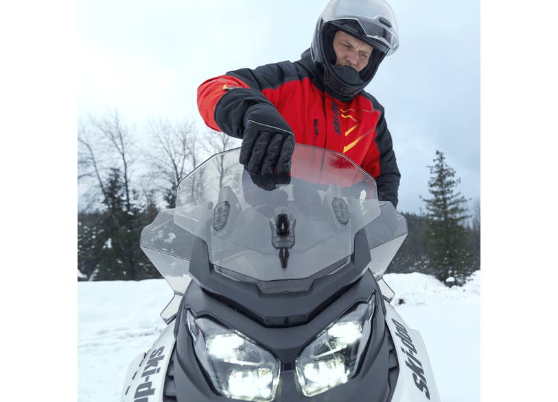 Rider adjusting the Ski-Doo Adjustable Windshield Medium to High with support