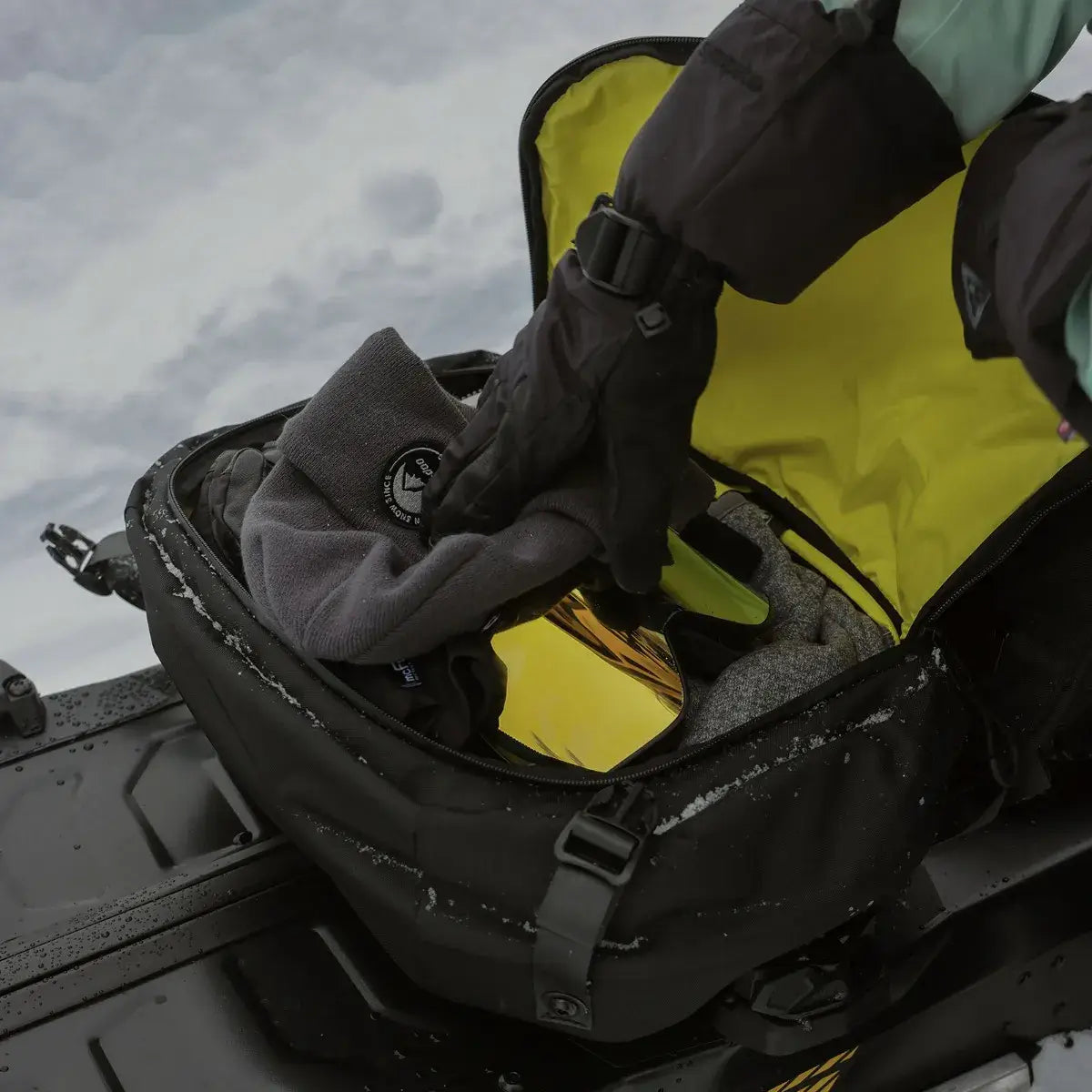 person stowing hat in deepsnow pro lightweight bag