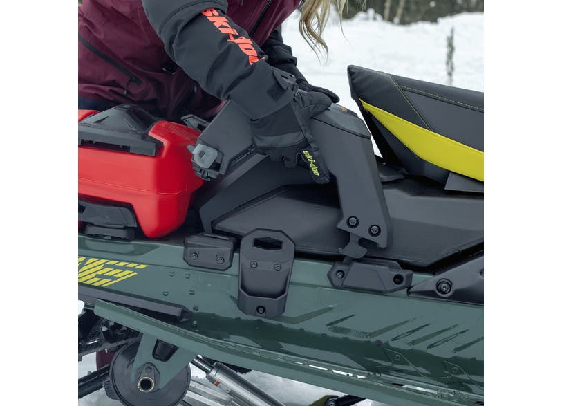 Rider mounting Ski-Doo LinQ 1+1 removable rack on green snowmobile with red fuel can attached