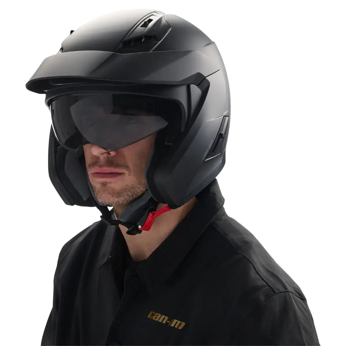 Person wearing a black motorcycle helmet with visor on a white background