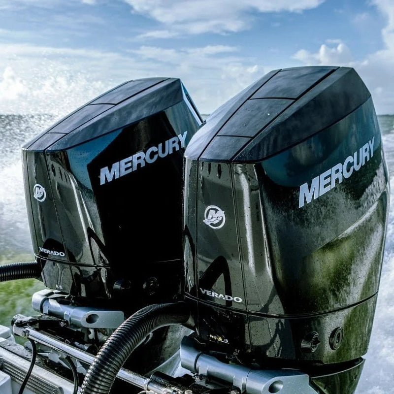 Two Mercury outboard motors on a boat with water splashing around.