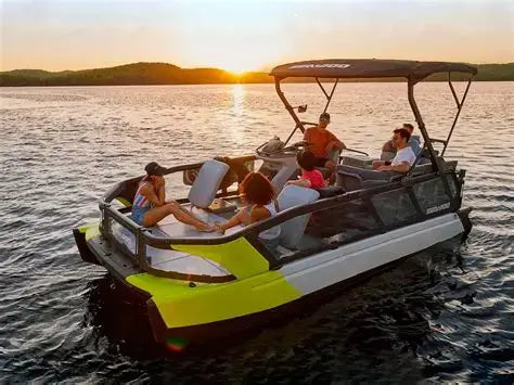 People enjoying a Sea-Doo Switch pontoon boat ride on a lake with a sunset in the background