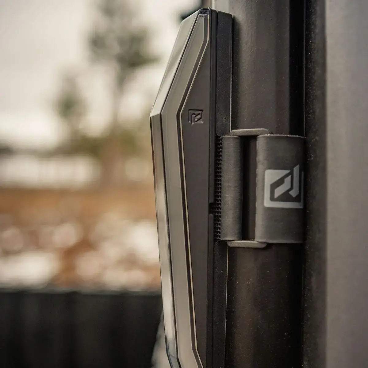 Close-up of a black vehicle door handle with a blurred outdoor background