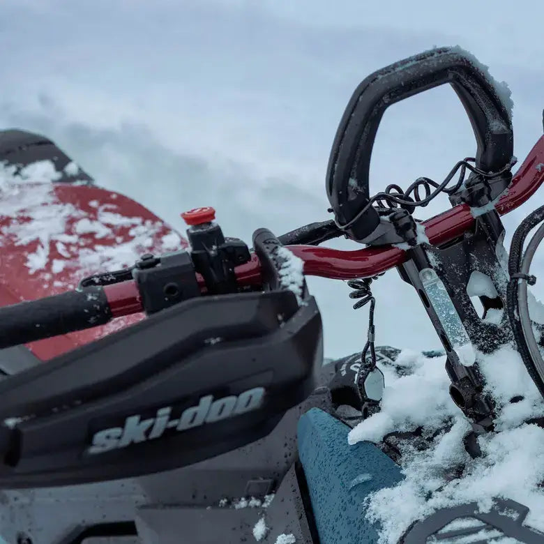 Close-up of a snowmobile with 'Ski-Doo' branding in a snowy environment