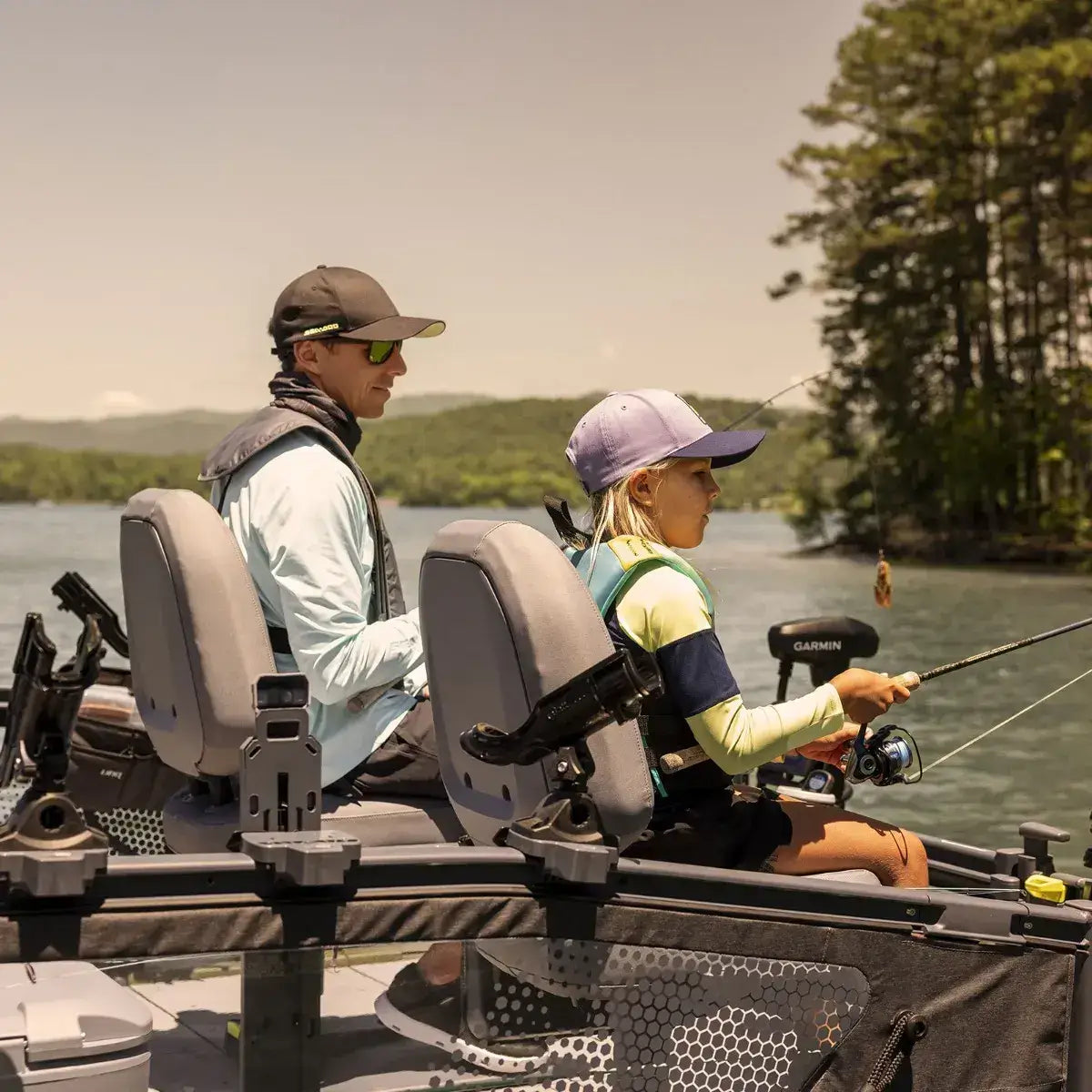 Two anglers seated in Quick-Attach Fishing Pedestal Seats on a Sea-Doo Switch pontoon, enjoying a day of fishing.