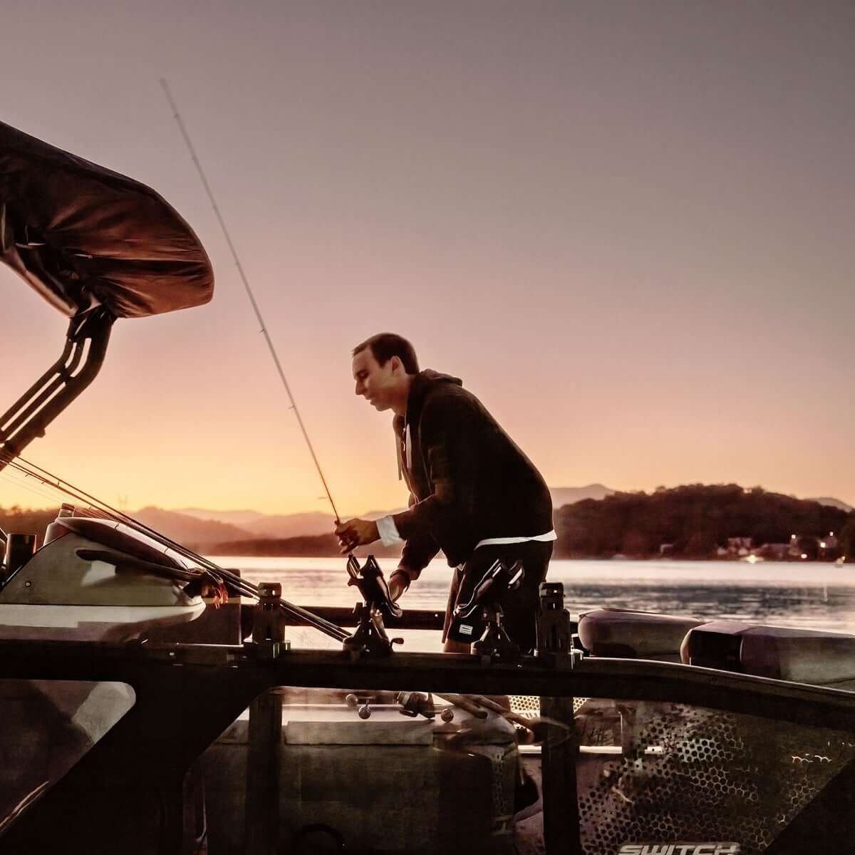 Angler using Sea-Doo Rail Rod Holder with LinQ Lite mounted on Switch pontoon boat at sunset