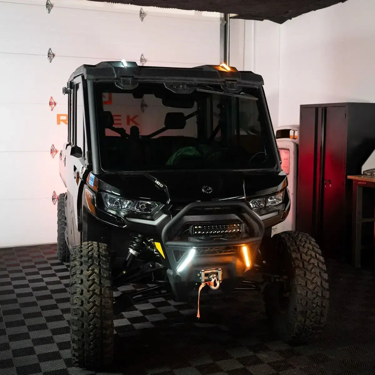 Black off-road vehicle in a garage with checkered floor