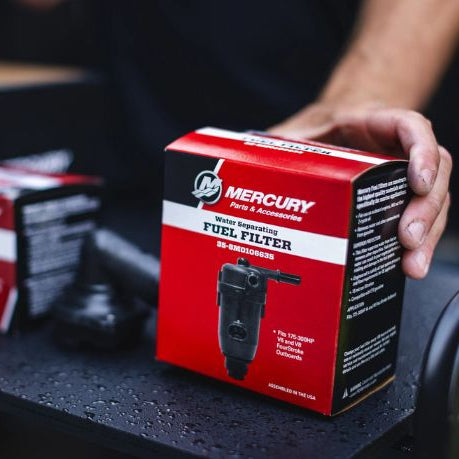 Red and black Mercury fuel filter packaging held by a person.