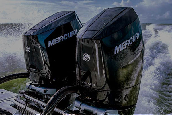 Two Mercury Marine outboard motors on the back of a boat, travelling across a lake