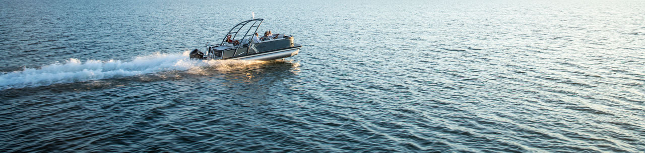 Boat speeding across a body of water with a clear sky.