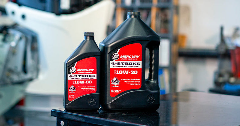 Two black jugs of Mercury 4-Stroke 30W-30 oil in a workshop setting.