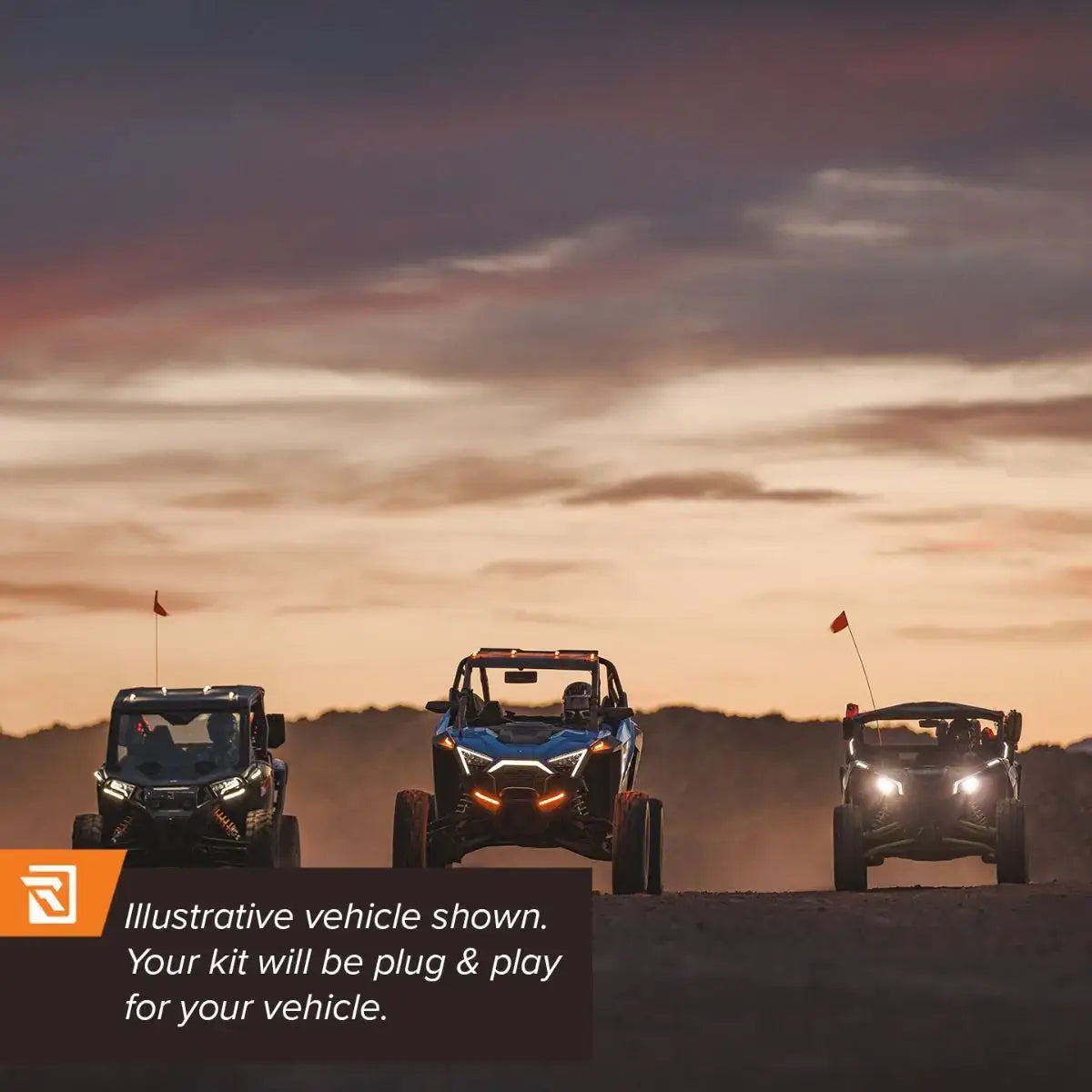 Three off-road vehicles on a dirt road with a sunset sky.