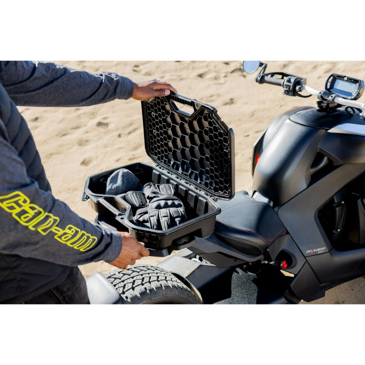 Rider opening black Can-Am LinQ 2.6 gal modular cargo box mounted on Ryker three-wheeler storing gloves
