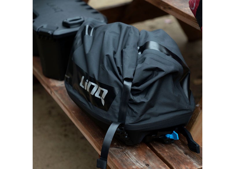 LinQ 10.6 US Gal 40L black roll-top bag with quick-attach mounting straps on wooden bench