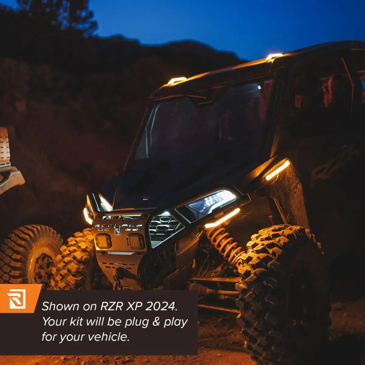 Off-road vehicle with illuminated headlights at night, showcasing rugged terrain.