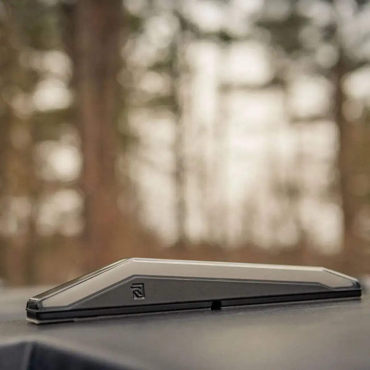 Ravek lighting system on roof of vehicle with blurred trees in background