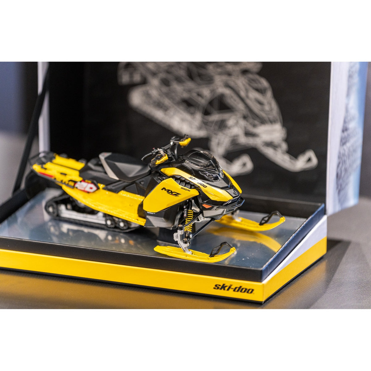 Ski-Doo MXZ XRS 20th Anniversary diecast snowmobile in presentation box with blueprint backdrop