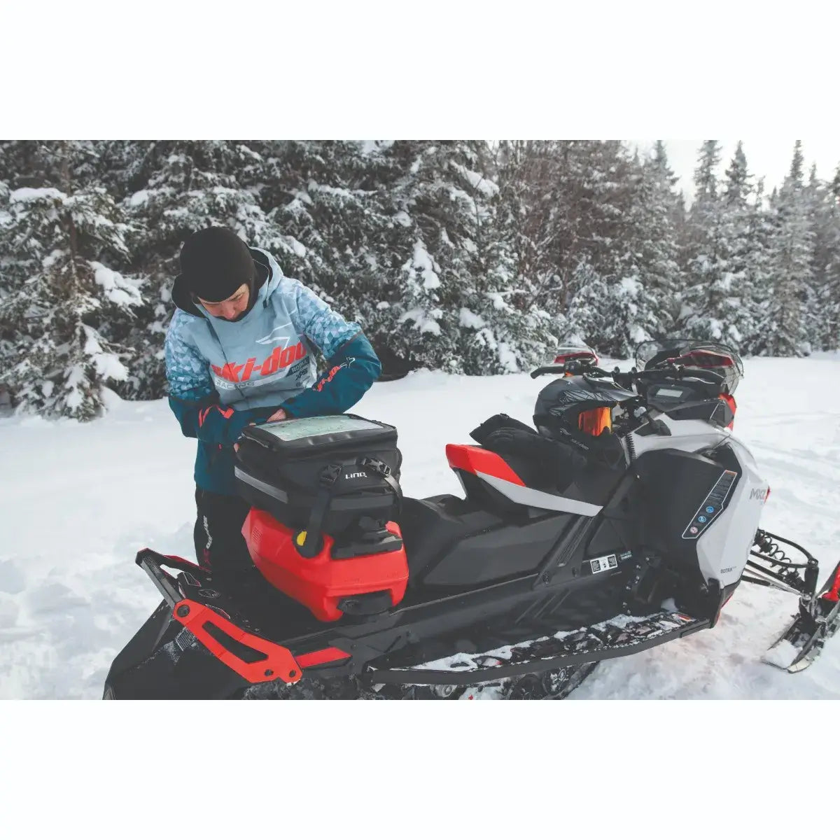Person on a snowmobile in a snowy forest