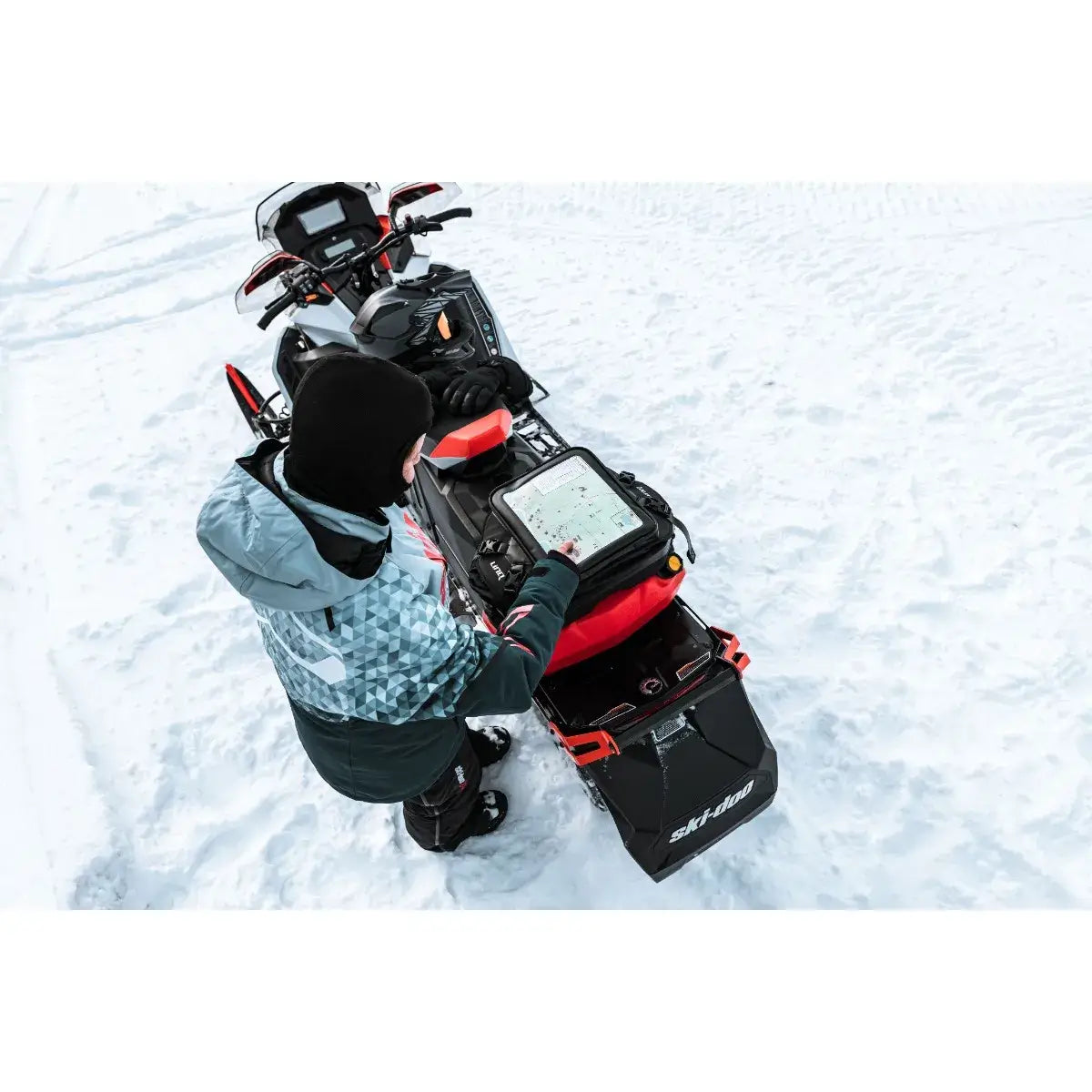 Person operating a snowmobile on a snowy landscape
